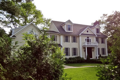 Ejemplo de fachada de casa beige y gris tradicional grande de dos plantas con revestimiento de vinilo, tejado a dos aguas y tejado de teja de madera