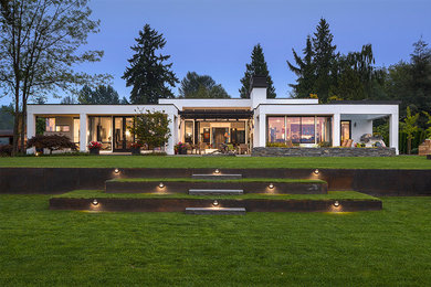 Example of a large minimalist white one-story stucco exterior home design in Seattle