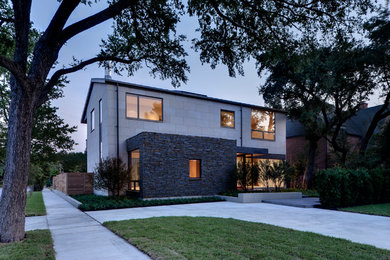 Large modern beige two-story stone gable roof idea in Dallas