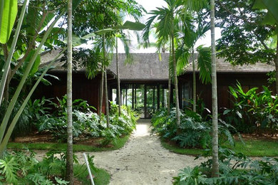 Immagine della villa grande tropicale a un piano con rivestimento in legno, tetto a padiglione e copertura in tegole