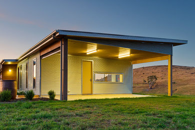 На фото: одноэтажный, серый дом в стиле модернизм с облицовкой из металла
