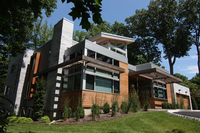 Modelo de fachada de casa multicolor actual grande de dos plantas con revestimiento de madera, tejado plano y tejado de varios materiales