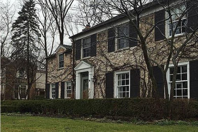 Example of a large 1960s beige brick house exterior design