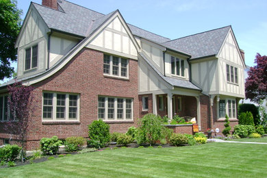 Ejemplo de fachada de casa multicolor de estilo americano grande de dos plantas con revestimientos combinados, tejado a cuatro aguas y tejado de teja de madera