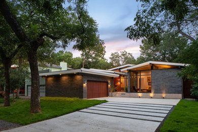Example of a small 1960s black one-story brick exterior home design in Dallas with a metal roof