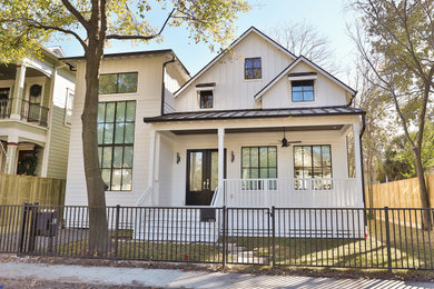 Aménagement d'une très grande façade de maison blanche campagne en panneau de béton fibré à un étage avec un toit à deux pans et un toit en métal.