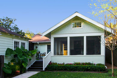 Diseño de fachada de casa verde de estilo americano pequeña de una planta con revestimiento de madera, tejado a dos aguas y tejado de teja de madera