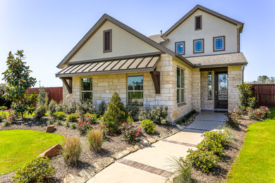 Example of a mid-sized trendy beige two-story stone exterior home design in Houston with a shingle roof