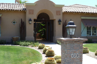 Inspiration for a mid-sized mediterranean beige one-story adobe exterior home remodel in Phoenix with a tile roof