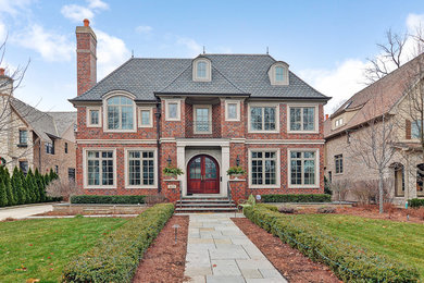 Inspiration for a large and red traditional two floor brick detached house in Chicago with a hip roof and a shingle roof.