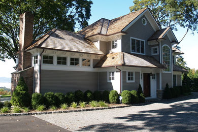 This is an example of a medium sized and beige classic two floor detached house in New York with vinyl cladding, a hip roof and a shingle roof.