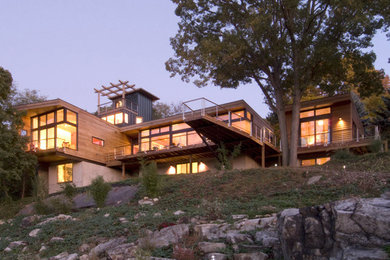 Diseño de fachada de casa marrón moderna extra grande de tres plantas con revestimientos combinados y tejado plano