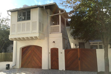 Idee per la facciata di una casa piccola beige stile marinaro a due piani con rivestimento in stucco e tetto a padiglione