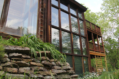 Immagine della villa grande marrone rustica a due piani con rivestimento in legno