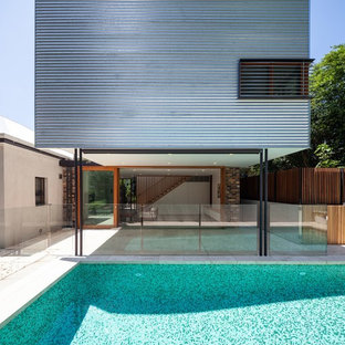 Imagen de fachada de casa blanca, contemporánea, de tamaño medio, de dos plantas, con revestimiento de metal, tejado plano y tejado de metal