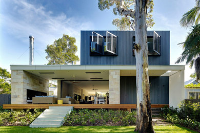 Immagine della villa nera contemporanea a due piani con rivestimenti misti e tetto piano