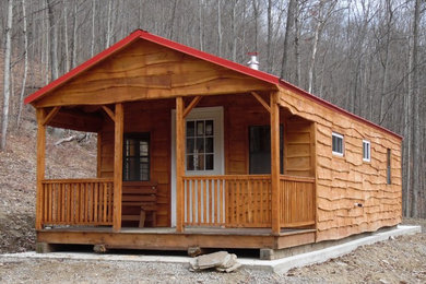 На фото: маленький, одноэтажный, деревянный, коричневый дом в стиле рустика с двускатной крышей для на участке и в саду, охотников с
