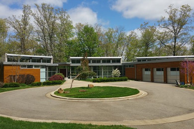 Photo of a large and brown modern bungalow detached house in Grand Rapids with wood cladding and a flat roof.