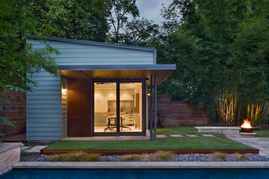 Photo of a small and green contemporary bungalow house exterior in Austin with concrete fibreboard cladding and a lean-to roof.