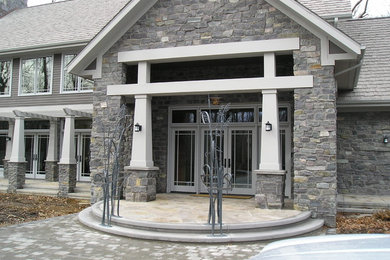 Diseño de fachada de casa gris clásica grande de dos plantas con revestimiento de piedra, tejado a dos aguas y tejado de teja de madera