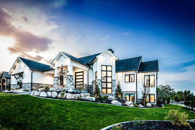 Example of a large transitional white two-story stone exterior home design in Salt Lake City with a shingle roof