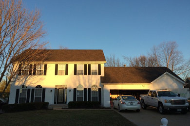 Example of a mid-sized arts and crafts white two-story vinyl exterior home design in St Louis with a hip roof