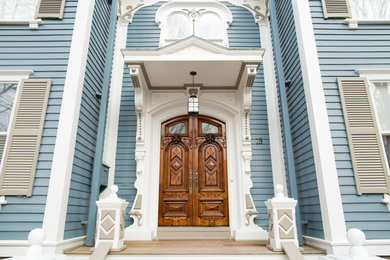 Large ornate blue wood exterior home photo in Boston