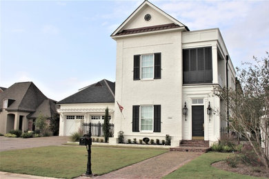Large transitional white two-story concrete house exterior photo in New Orleans with a shingle roof