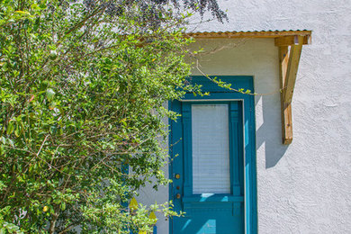 Inspiration for a small southwestern white one-story stucco exterior home remodel in Nashville with a shingle roof