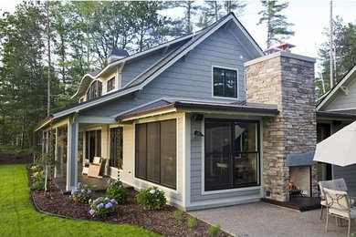 Example of a mid-sized arts and crafts gray two-story wood exterior home design in Other with a shed roof