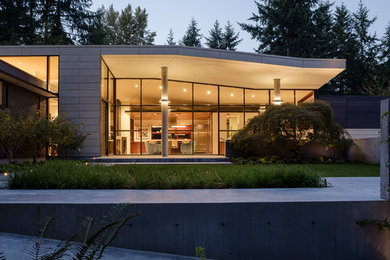 Modern white one-story concrete fiberboard exterior home idea in Seattle with a hip roof