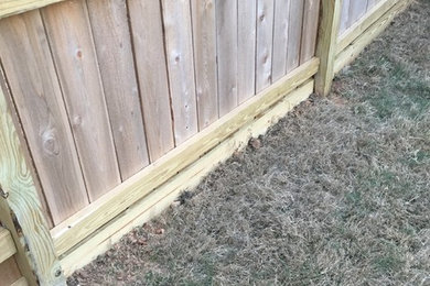 Install boards at the bottom of cedar fence to help keep owners dog in the yard.