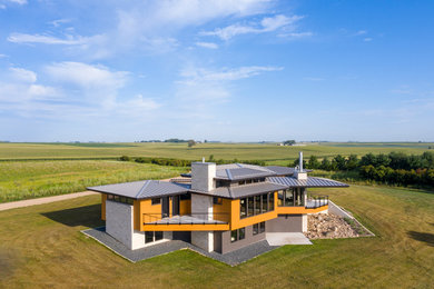 Imagen de fachada de casa multicolor contemporánea grande de dos plantas con revestimientos combinados, tejado a cuatro aguas y tejado de metal
