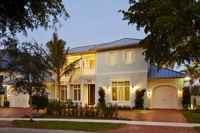 Large beach style blue two-story stucco exterior home photo in Miami