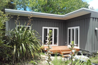 This is an example of a small and gey contemporary bungalow house exterior in Auckland.
