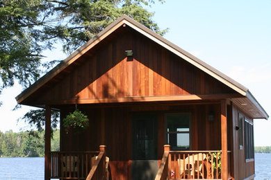 Ejemplo de fachada de estilo americano de tamaño medio de dos plantas con revestimiento de madera y tejado a dos aguas