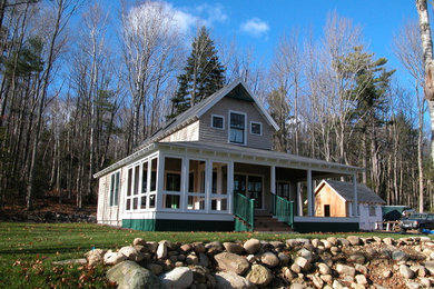 Imagen de fachada de casa beige tradicional de tamaño medio de dos plantas con revestimiento de madera, tejado a dos aguas y tejado de teja de madera