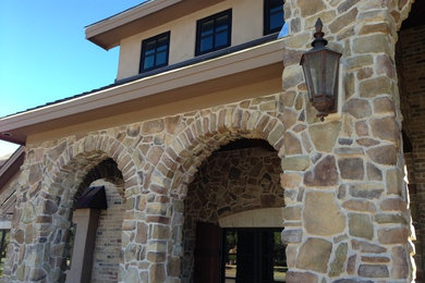 Large tuscan beige one-story stone exterior home photo in Austin