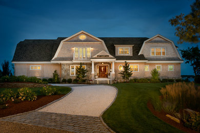 Foto della villa grande beige stile marinaro a due piani con rivestimento in legno, tetto a mansarda e copertura a scandole