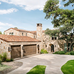 Mediterranean multicolored two-story stone exterior home idea in Austin with a tile roof