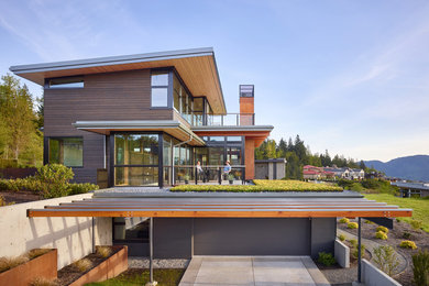 Contemporary brown three-story metal house exterior idea in Seattle with a shed roof and a metal roof