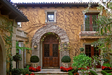 Diseño de fachada beige mediterránea de tamaño medio de dos plantas con revestimiento de ladrillo y tejado plano