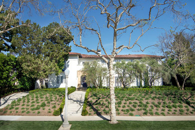 Großes, Zweistöckiges Mediterranes Haus mit Putzfassade, weißer Fassadenfarbe und Walmdach in Los Angeles