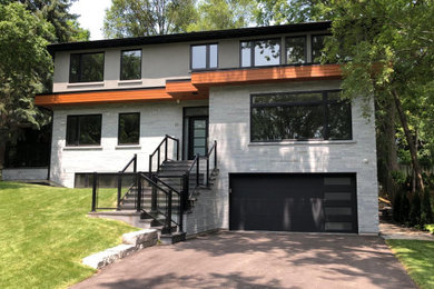 Imagen de fachada de casa gris contemporánea grande de dos plantas con revestimientos combinados, tejado plano y techo verde