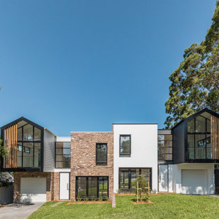 Cette photo montre une façade de maison double moderne de taille moyenne et à un étage.