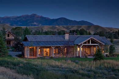 Inspiration for a rustic brown one-story wood exterior home remodel in Other with a mixed material roof
