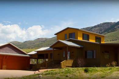 Foto de fachada de casa multicolor rústica de tamaño medio de dos plantas con revestimiento de madera, tejado a dos aguas y tejado de metal
