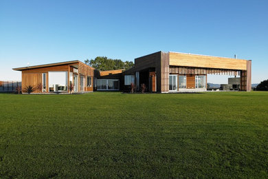Diseño de fachada de casa marrón contemporánea grande de una planta con revestimiento de madera