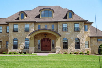 Large mediterranean beige two-story stone exterior home idea in Other