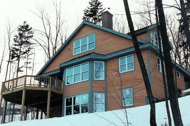 Imagen de fachada de casa de estilo americano grande de dos plantas con revestimiento de madera, tejado a dos aguas y tejado de teja de madera